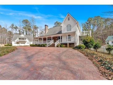 Charming white two-story home with a long front porch and a spacious driveway at 300 Mill Creek Ct, Acworth, GA 30101