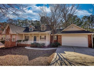 Charming single-Gathering home boasts a covered porch, brick accents and a two-car garage at 424 Cannonball Ct, Stockbridge, GA 30281