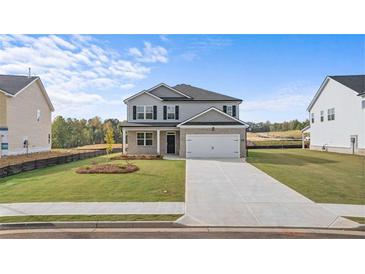 Charming two-story home with manicured lawn and neutral gray color palette at 604 Kimberwick Dr, Locust Grove, GA 30248