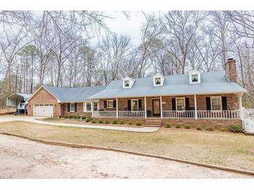 Charming brick home featuring a long porch with dormer windows and a well-maintained front yard at 1376 Highway 138 E, Stockbridge, GA 30281