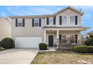 Charming two-story home with a well-manicured front yard and a two-car garage, perfect for a Gathering at 2011 Farm Hill Ct, Stockbridge, GA 30281