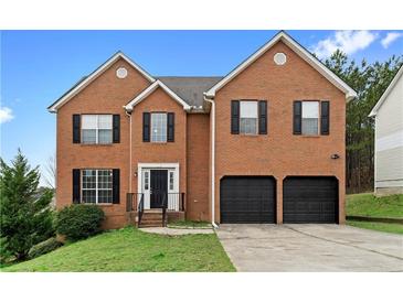 Two story brick home with a well-manicured lawn, a two car garage and black shutters at 2557 Tolliver Dr, Ellenwood, GA 30294
