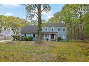 Charming two-story home features a light-blue exterior, landscaped yard, and mature trees at 3430 Pate Rd, Snellville, GA 30078