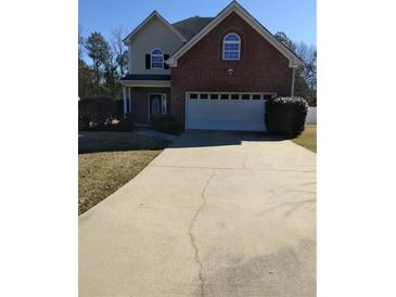 Traditional two-story brick home featuring an attached two-car garage and mature landscaping at 10 Chapman Way, Covington, GA 30016