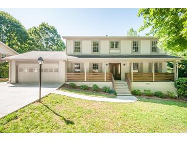 Charming two-story home with a landscaped front yard, two-car garage, and inviting front porch at 2647 Wood Hollow Dr, Dunwoody, GA 30360