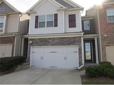 Charming two-story home with stone accents, a white three-car garage, and well-maintained landscaping at 3352 Brockenhurst Dr, Buford, GA 30519