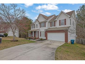 Charming two-story home with a two-car garage and manicured front lawn at 1514 Log Cabin Ln, Lawrenceville, GA 30045