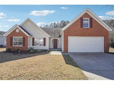 Charming home with a two-car garage, brick accents, and manicured lawn at 1955 Nichols Landing Way, Dacula, GA 30019