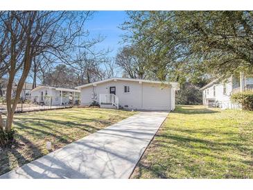 Charming single-story home featuring a well-maintained lawn, inviting walkway, and freshly painted exterior at 2917 1St Sw Ave, Atlanta, GA 30315