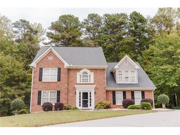 Charming two-story brick home with a manicured lawn and mature landscaping at 3500 Parkwood Hills Ct, Snellville, GA 30078