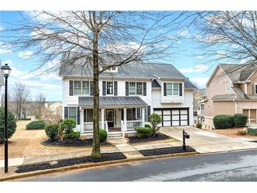 Charming two-story home with a well-manicured lawn and a welcoming front porch at 650 Village Crest Dr, Suwanee, GA 30024