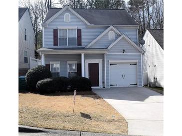 Two-story home featuring light blue siding, dark trim, and an attached one car garage at 235 Woodland Way, Canton, GA 30114