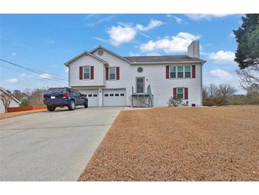 Charming two-story home featuring vinyl siding, red shutters, and an attached two-car garage at 210 Meadow View Dr, Grayson, GA 30017