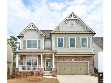 Charming two-story home with stone accents, a welcoming porch, and a two-car garage at 1760 Grand Oaks Drive, Woodstock, GA 30188