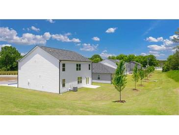 View of a white two-story home featuring a well-manicured lawn on a bright and sunny day at 8599 Secretariat Dr, Lithonia, GA 30058