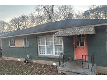 Charming single-story home featuring a bright pink front door and mature trees in the background at 2925 Delowe Dr, Atlanta, GA 30344