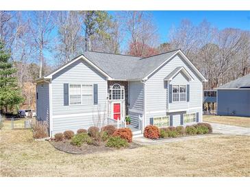 Charming two-story home with gray siding, dark shutters, a red front door, and neatly manicured landscaping at 4046 Harvest Ridge Dr, Douglasville, GA 30135