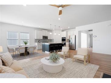 Bright, open-concept living space flows into a modern kitchen with a large island and stainless steel appliances at 505 Windy Ridge Ct, Canton, GA 30114