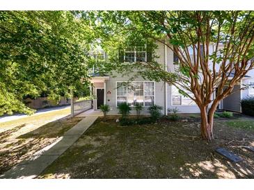 Charming two-story townhome featuring a walkway up to the front door and mature shade trees at 215 Odyssey Turn, Conyers, GA 30012