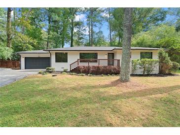 Charming white brick ranch-style home with well-maintained front yard and a dark gray garage door at 3363 Briarcliff Ne Rd, Atlanta, GA 30345