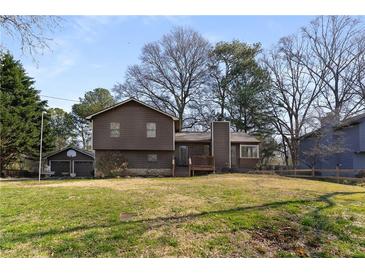 Traditional home featuring a brown exterior, a detached garage, and a spacious front yard at 4223 Mountain Glen Trce, Snellville, GA 30039