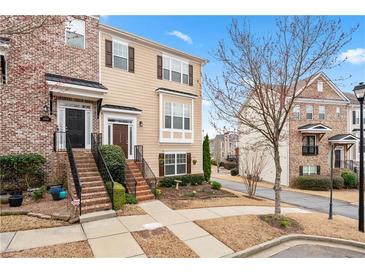 Charming townhome with brick and siding, featuring a landscaped front yard and inviting entrance at 1262 Park Pass Row, Suwanee, GA 30024