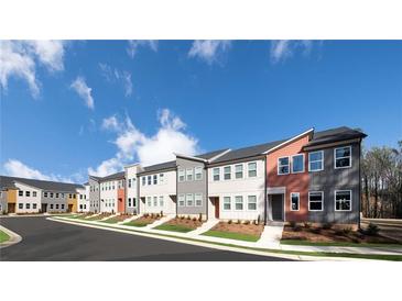 Modern townhomes with colorful exteriors and well-manicured lawns present an inviting street view at 1592 Driggs Nw Dr # 165, Atlanta, GA 30318