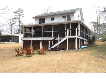 Expansive backyard featuring a screened porch, stairs, and a charming seating area with wooden chairs at 4040 Merritt Dr, Cumming, GA 30041