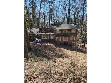 Charming multi-level home with brick and siding exterior, surrounded by mature trees in a serene setting at 805 Loridans Ne Cir, Atlanta, GA 30342