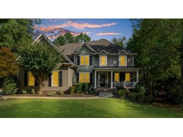 Inviting two-story home featuring a covered front porch and lush green lawn at 1416 Elgin Way, Cumming, GA 30041