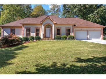 Charming single story home with manicured lawn, mature landscaping, and an attached two car garage at 427 Picketts Lake Dr, Acworth, GA 30101