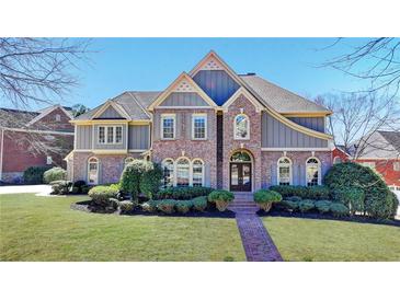 Stunning two-story brick home with manicured lawn and walkway leading to the front door at 4634 Meadow Bluff Ln, Suwanee, GA 30024