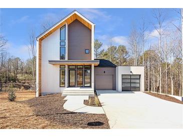 Modern two-story home featuring mixed materials, clean lines, and an attached two-car garage at 165 Cedarwood Ln, Roswell, GA 30075