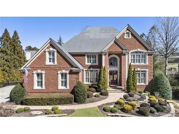 Beautiful two-story brick home with manicured landscaping and symmetrical design at 4235 Iron Duke Ct, Peachtree Corners, GA 30097
