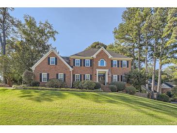 Stately brick two-story home with manicured lawn and mature trees, offering classic curb appeal at 4742 Balmoral Ne Way, Marietta, GA 30068