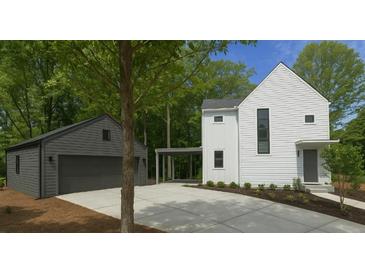 Modern home featuring a white exterior, gray garage, and a concrete driveway at 145 Cedarwood Ln, Roswell, GA 30075