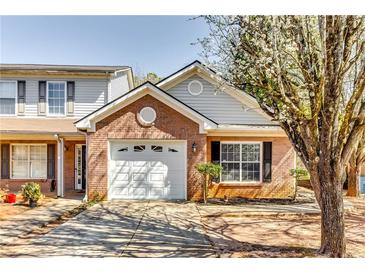 Charming brick home featuring a one-car garage and blossoming tree at 2139 Hickory Se Bnd # E, Conyers, GA 30013