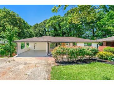 Charming one-story home featuring a carport, manicured lawn, and blooming bushes at 2682 Miriam Ln, Decatur, GA 30032