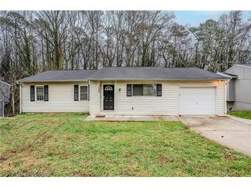 Charming single-story home with a well-maintained lawn and attached single car garage at 1492 Cobb Branch Dr, Decatur, GA 30032