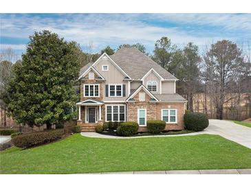 Charming two-story home with a stone and siding facade, a manicured lawn, and mature landscaping at 118 Fairway Overlook Dr, Acworth, GA 30101