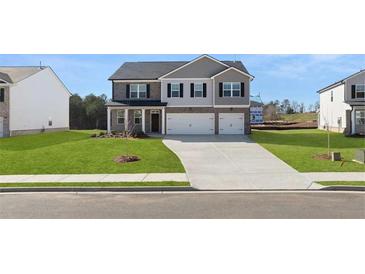 Charming two-story home with a manicured lawn and a two-car garage at 629 Kimberwick Dr, Locust Grove, GA 30248