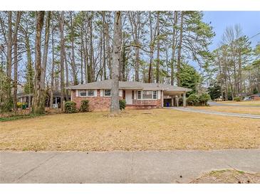 Cozy brick home featuring a well-manicured front yard and covered carport at 1690 Carter Rd, Decatur, GA 30032