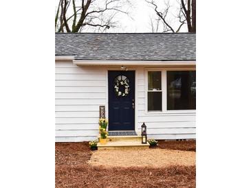 Charming front entrance with a navy door, decorative wreath, and fresh yellow flowers creating an inviting curb appeal at 3601 Orchard Cir, Decatur, GA 30032