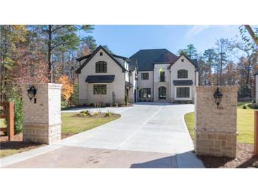 Stunning two-story home featuring a circular driveway and well-manicured lawn at 10745 Shallowford Rd, Roswell, GA 30075