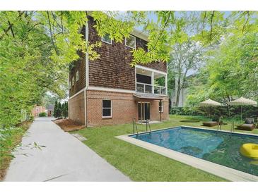 Stunning backyard with pool, lounge chairs, and lush greenery offers a private outdoor retreat at 1303 N Druid Hills Ne Rd, Brookhaven, GA 30319