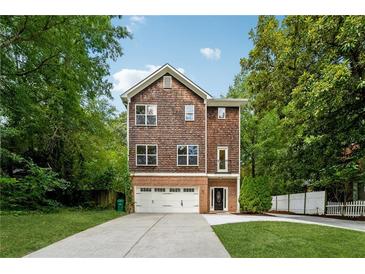 Charming two-story home with shingle and brick facade, complemented by a well-manicured lawn and ample driveway at 1303 N Druid Hills Ne Rd, Brookhaven, GA 30319