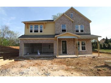 Two-story home with brick and siding exterior, open garage, and covered porch, in mid-construction phase at 206 Wild Ginger Bend, Woodstock, GA 30188