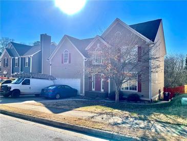 Traditional two-story home with neutral siding, red shutters, two-car garage and well-maintained landscaping at 929 Bexhill Dr, Lawrenceville, GA 30043