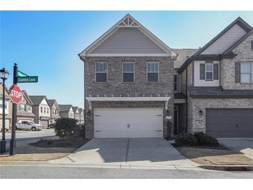 Charming two-story home with gray brick and two-car garage, set in a suburban neighborhood at 8605 Gladden Ln, Suwanee, GA 30024