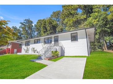 Charming exterior of a freshly painted white house with a well-manicured lawn and a inviting stairway to the front door at 674 Valleyview Dr, Forest Park, GA 30297